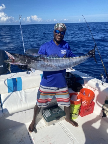 Lenroy with fishing rod on a boat